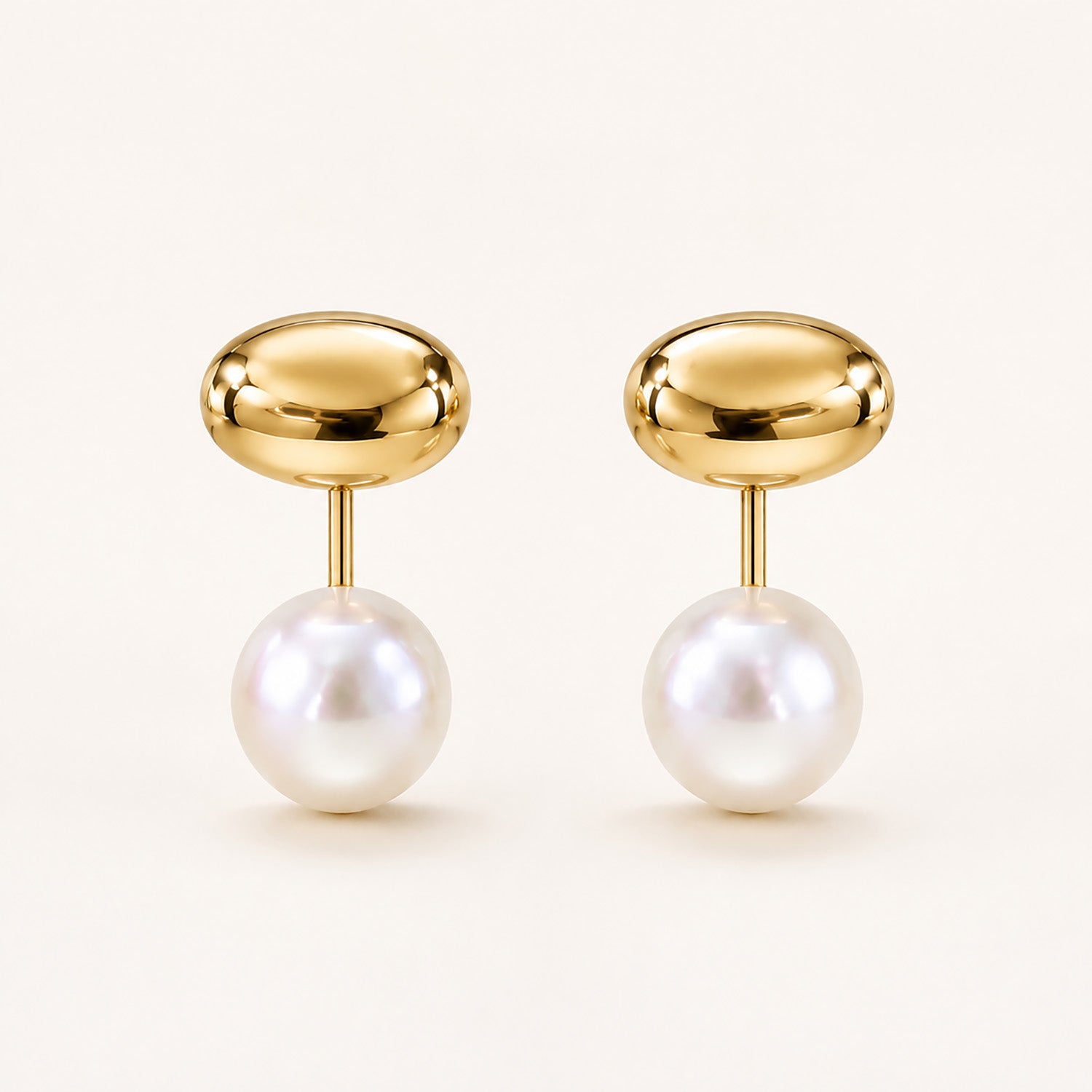 Minimalist front-back stud earrings featuring a polished gold-tone bean and a freshwater pearl drop on a clean white background.