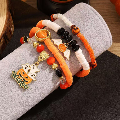 Close-up of 4-piece Halloween stackable bracelet set with orange and black clay beads, ghost and pumpkin charms