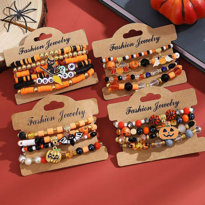 4 different Halloween clay bead stacked bracelet sets on paper display cards featuring cat, bat, and wicked pumpkin charms