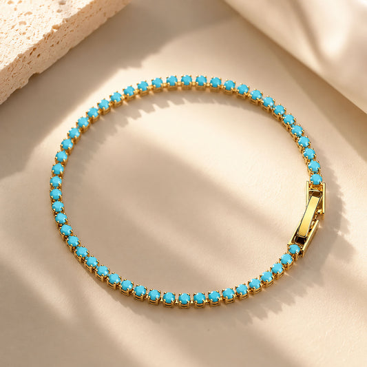 Vibrant-turquoise-tennis-chain-bracelet-arranged-in-a-circle-on-an-aesthetic-warm-sand-background