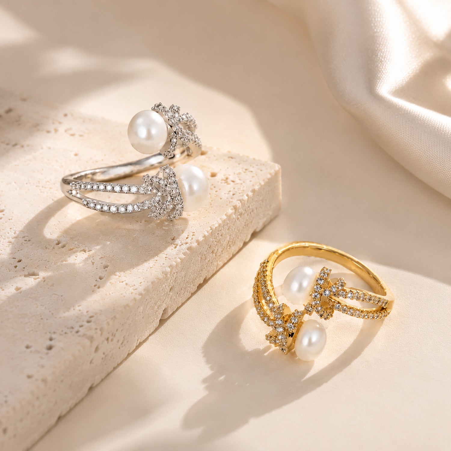 Beautiful display comparing adjustable freshwater pearl and zircon knot rings in both 18K gold-tone and white gold-tone on a textured aesthetic stone.