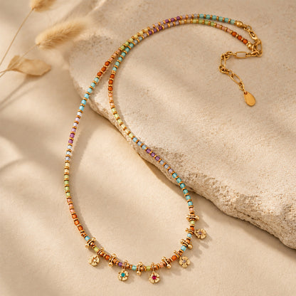 Boho-chic colorful beaded necklace draped elegantly over a textured stone in warm sunlight.
