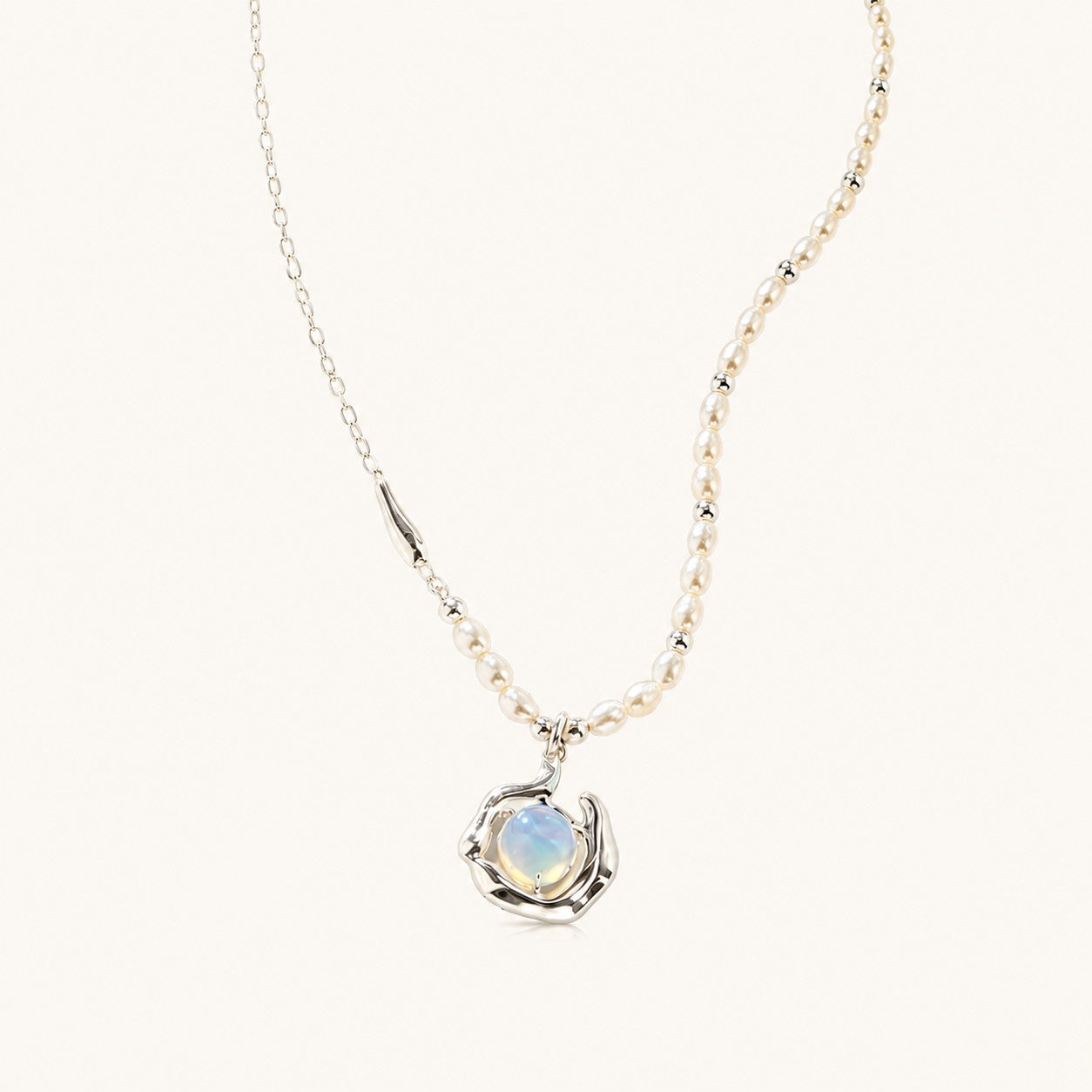 Flatlay view of asymmetric freshwater pearl necklace with silver chain and molten fluid opaline pendant