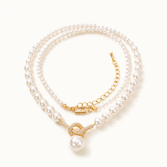 18K gold-tone twisted knot aurora pearl necklace with adjustable chain on a clean white background.