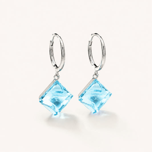 Minimalist white gold-tone hoop earrings with square ocean blue zirconia pendants on a clean white background.