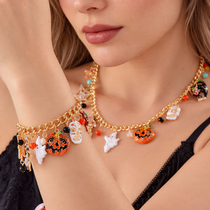 Close-up of model wearing matching gold Halloween charm necklace and charm bracelet with black dress
