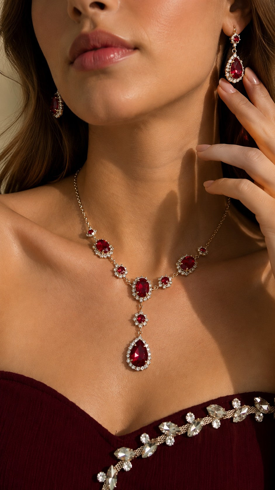 Close up of model wearing royal red teardrop pendant necklace and dangle halo earrings