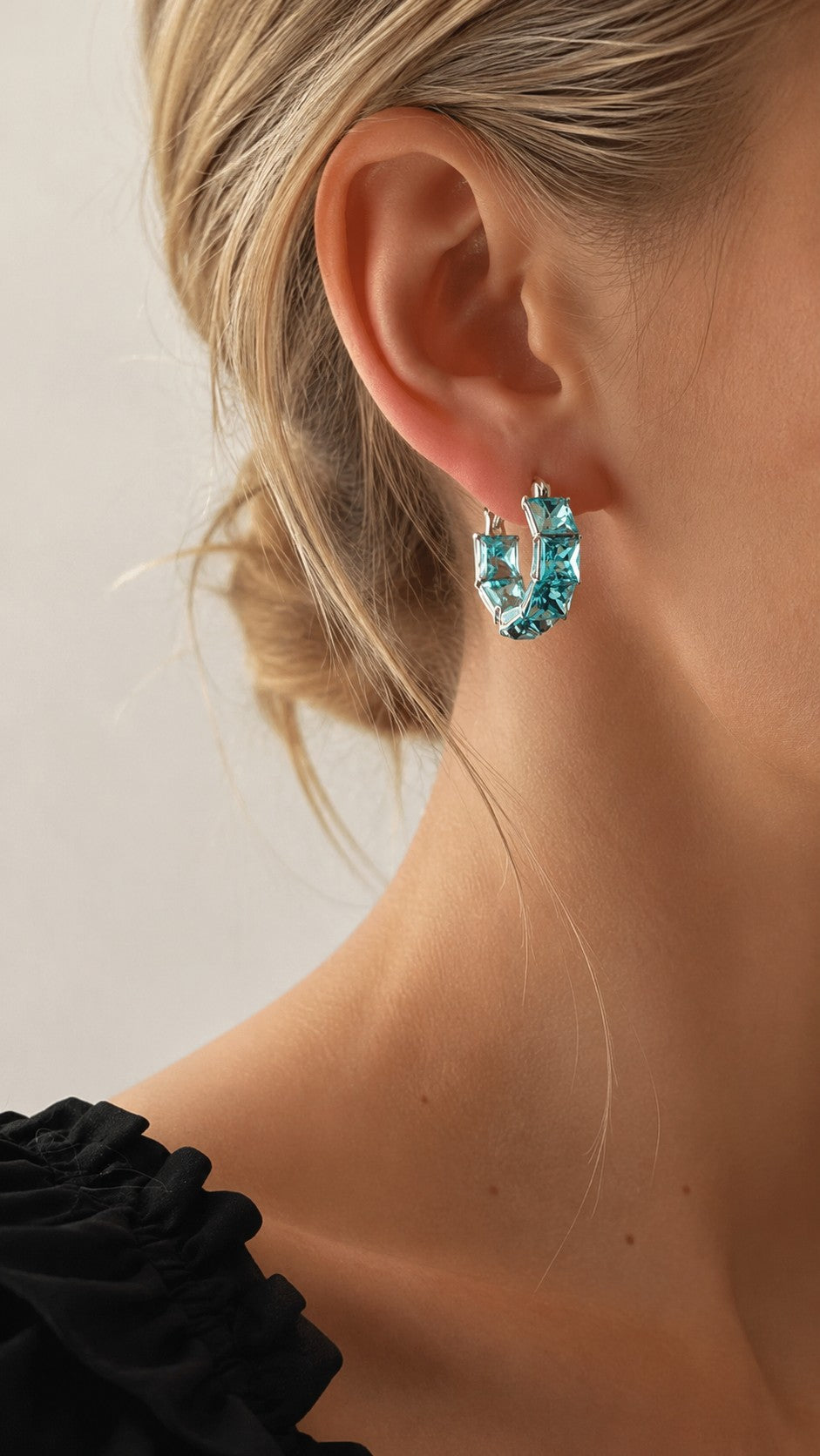 Close up of model in black top wearing ocean ice blue CZ statement hoop earring