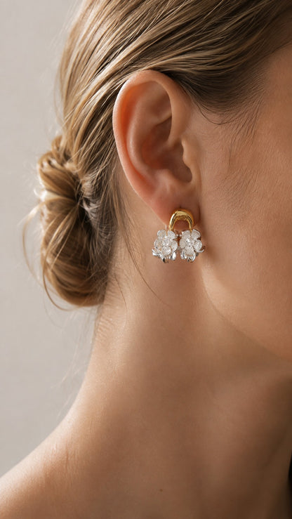 Detailed ear macro shot of model wearing gold arch silver floral cluster earring