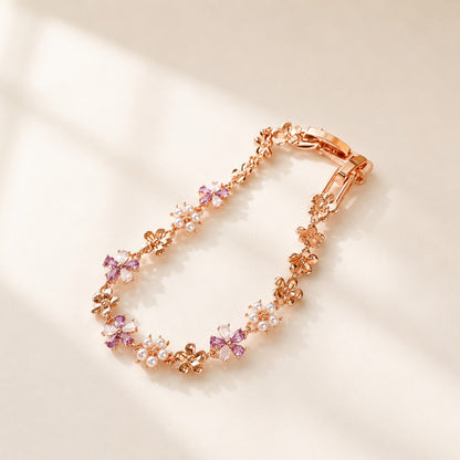 Angled view showing the fold-over clasp and delicate purple crystal flowers of rose gold bracelet