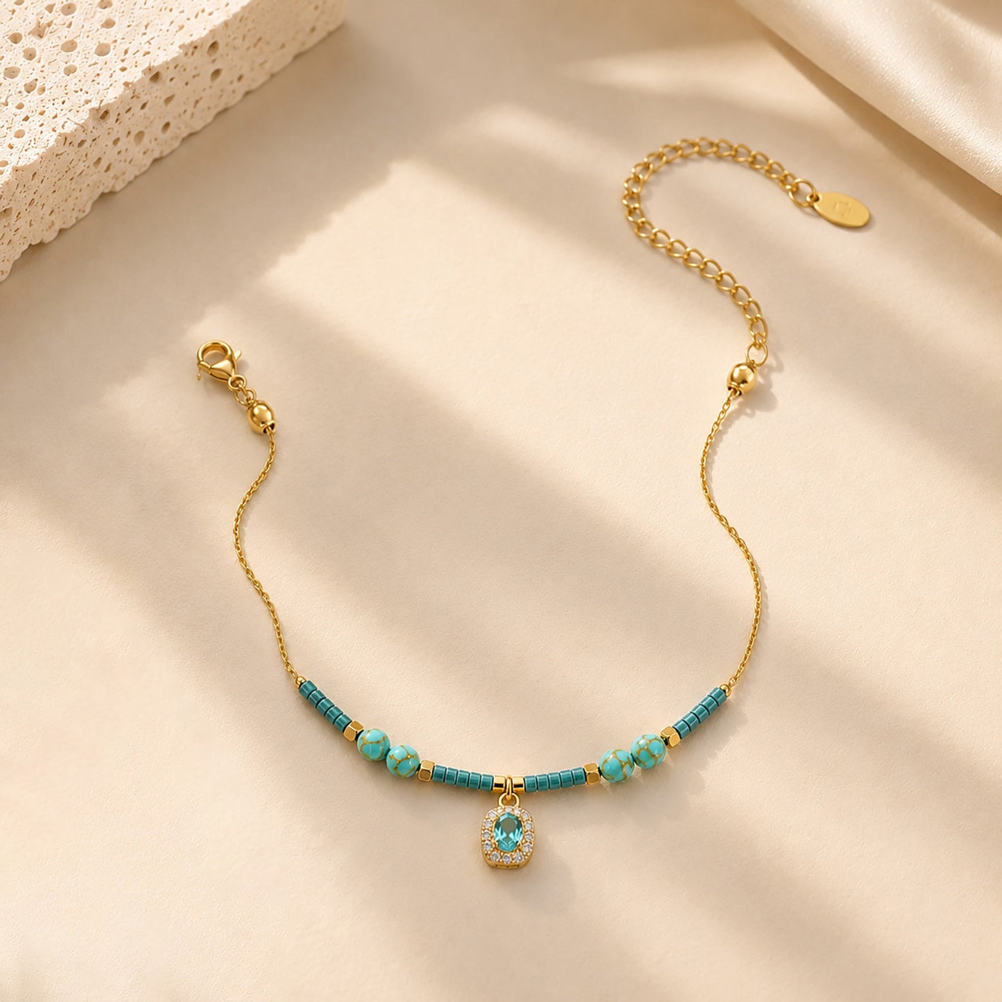 Close-up of water-resistant titanium steel anklet with blue beads and sparkling zirconia.