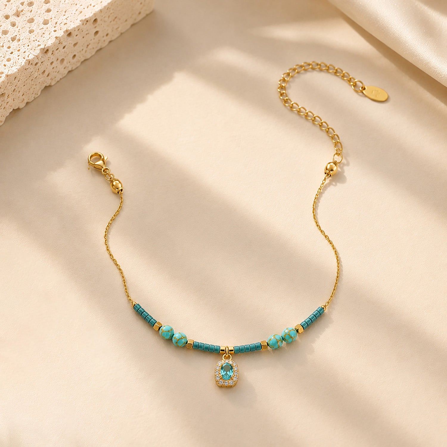 Close-up of water-resistant titanium steel anklet with blue beads and sparkling zirconia.