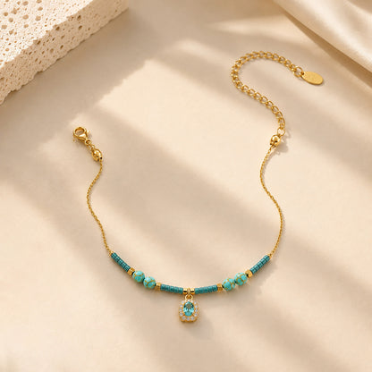 Close-up of water-resistant titanium steel anklet with blue beads and sparkling zirconia.