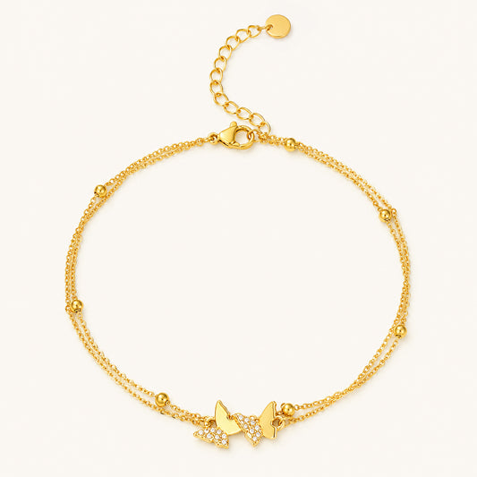 Minimalist double-layer gold-tone anklet featuring sparkling zirconia butterflies on a clean white background.