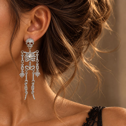 Close-up side profile of model wearing silver rhinestone skeleton dangle earrings
