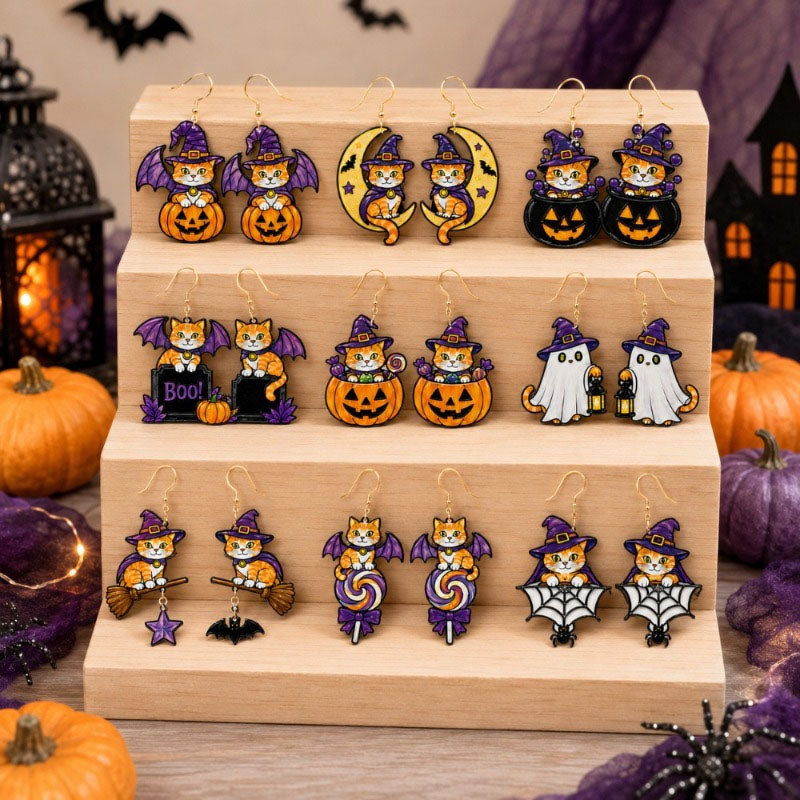 All 9 pairs of Halloween witch cat drop earrings arranged on a wooden display stand with pumpkins
