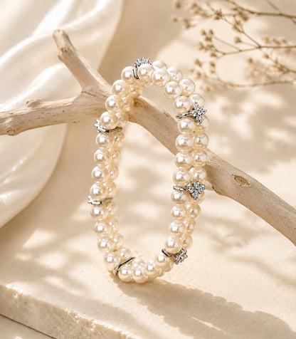 Elegant double-layer aurora pearl bracelet draped over natural driftwood.