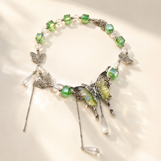 Fairycore green crystal beaded choker with large butterfly pendant and cascading drops on flat background