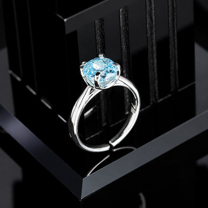 Single 8mm glacier blue round cubic zirconia solitaire ring in four-prong silver setting on black display