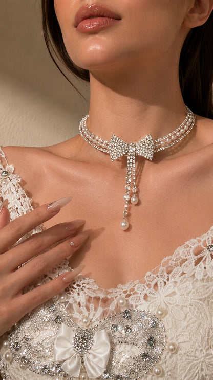Side view detail of model wearing triple-strand rhinestone bow pearl choker for evening party look