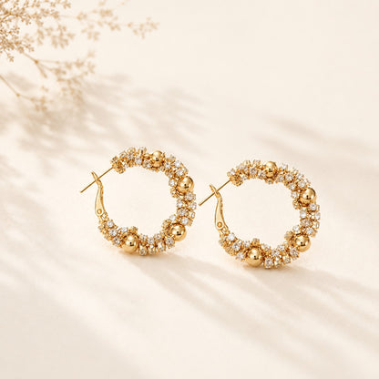 Flatlay view of pair of 2.8cm gold plated bubble bead and pave cz cluster hoop earrings