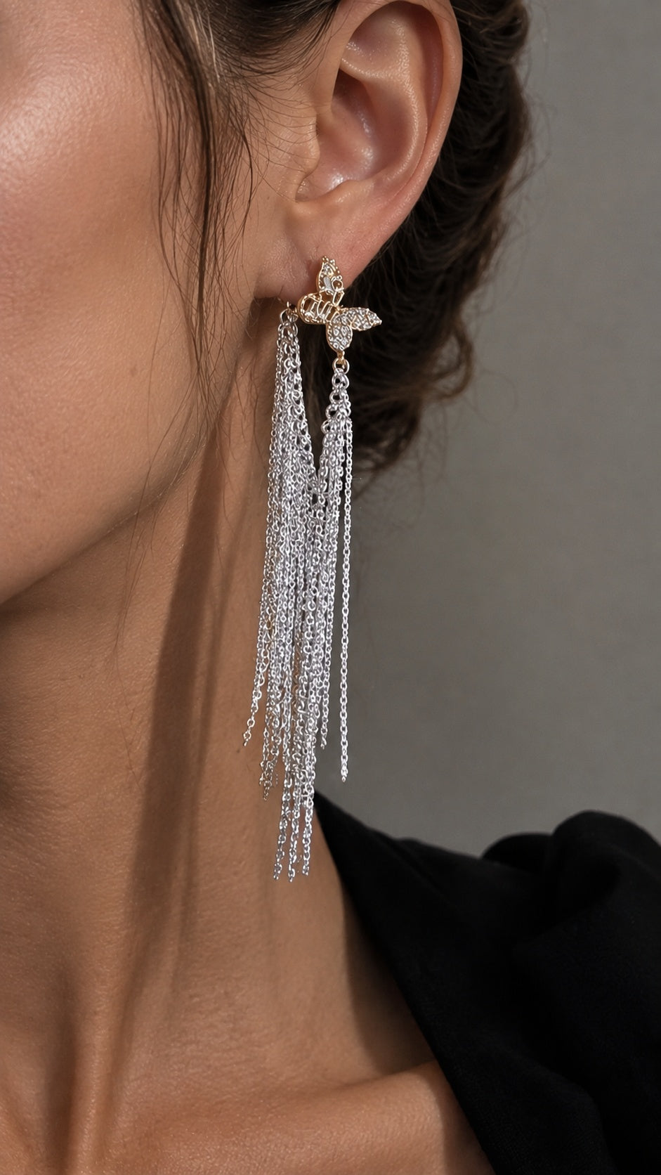Close up of model wearing long mixed metal gold butterfly silver waterfall fringe drop earrings