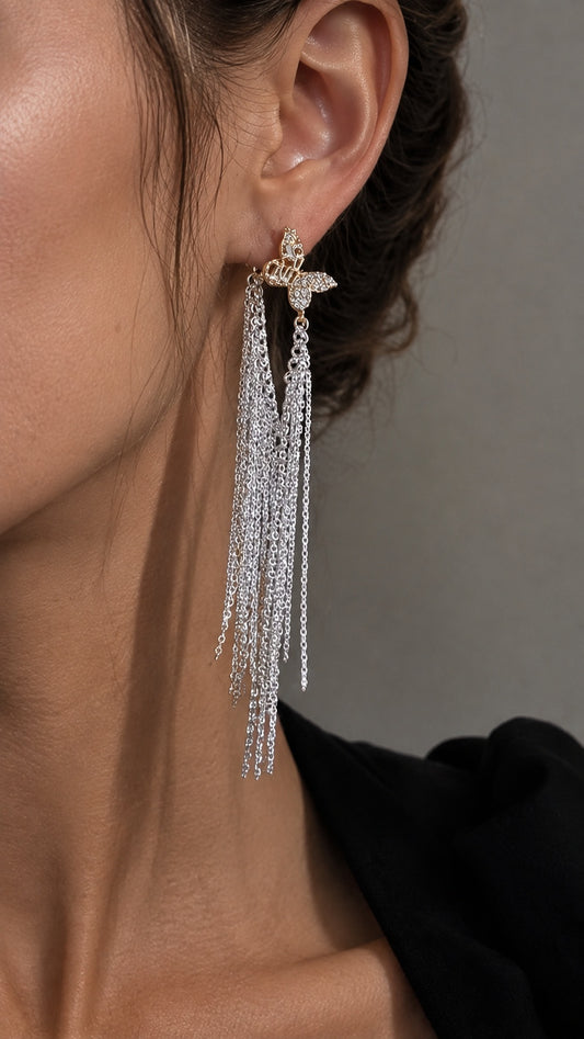 Close up of model wearing long mixed metal gold butterfly silver waterfall fringe drop earrings
