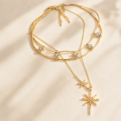 Detailed close-up of a sparkling gold-tone layered starburst necklace resting gracefully in warm, natural sunlight.