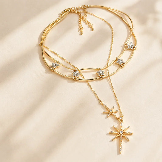 Detailed close-up of a sparkling gold-tone layered starburst necklace resting gracefully in warm, natural sunlight.