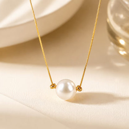 Macro detail of a lustrous 1cm aurora pearl pendant on a fine gold-tone chain.