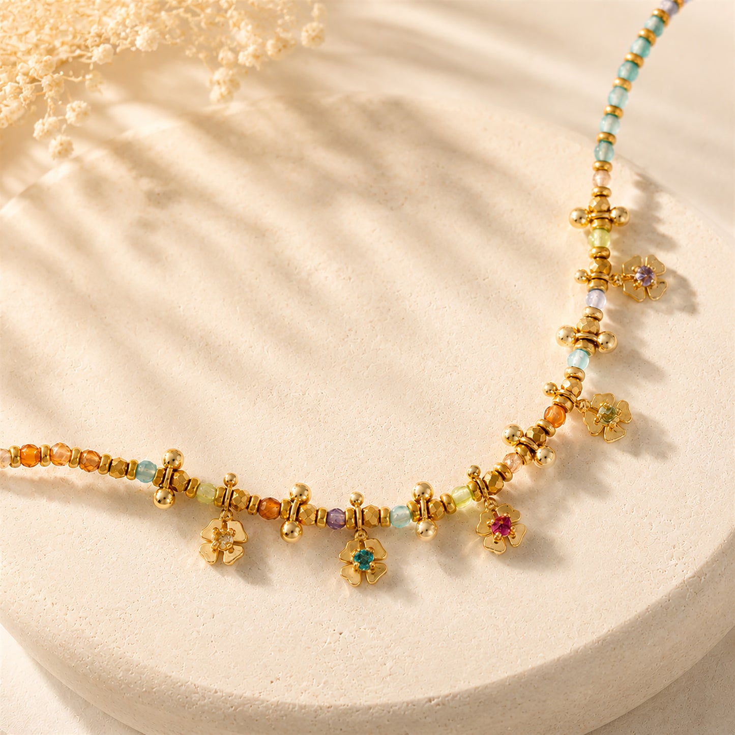 Macro detail showing sparkling crystals and natural stones on a gold-tone beaded flower necklace.