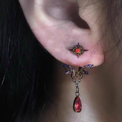Close-up of model wearing gothic bat wing ear jacket earring with dangling blood red crystal teardrop
