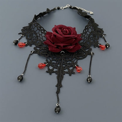 Gothic black lace choker necklace with dark red velvet rose and cascading crimson crystal beads on grey background