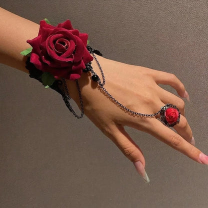 Model wearing gothic crimson velvet rose hand harness bracelet connected with black chain to finger ring