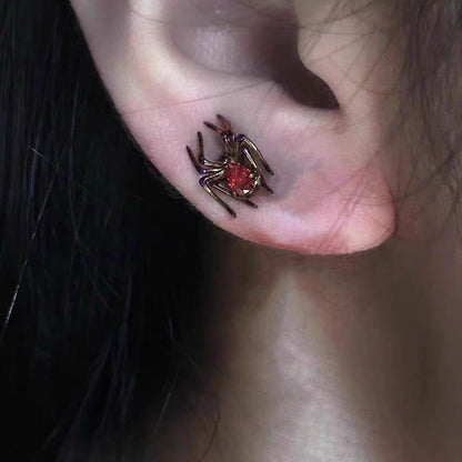 Model wearing gothic dark gunmetal spider stud earring with crimson red CZ crystal body