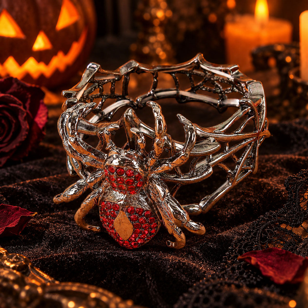 Close-up of gothic rhinestone spider cuff bracelet on black lace with Halloween pumpkins and candles