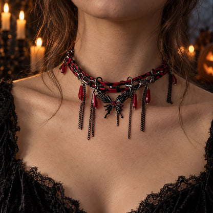 Close-up of model wearing vampire gothic leather chain butterfly necklace in candlelit Halloween setting