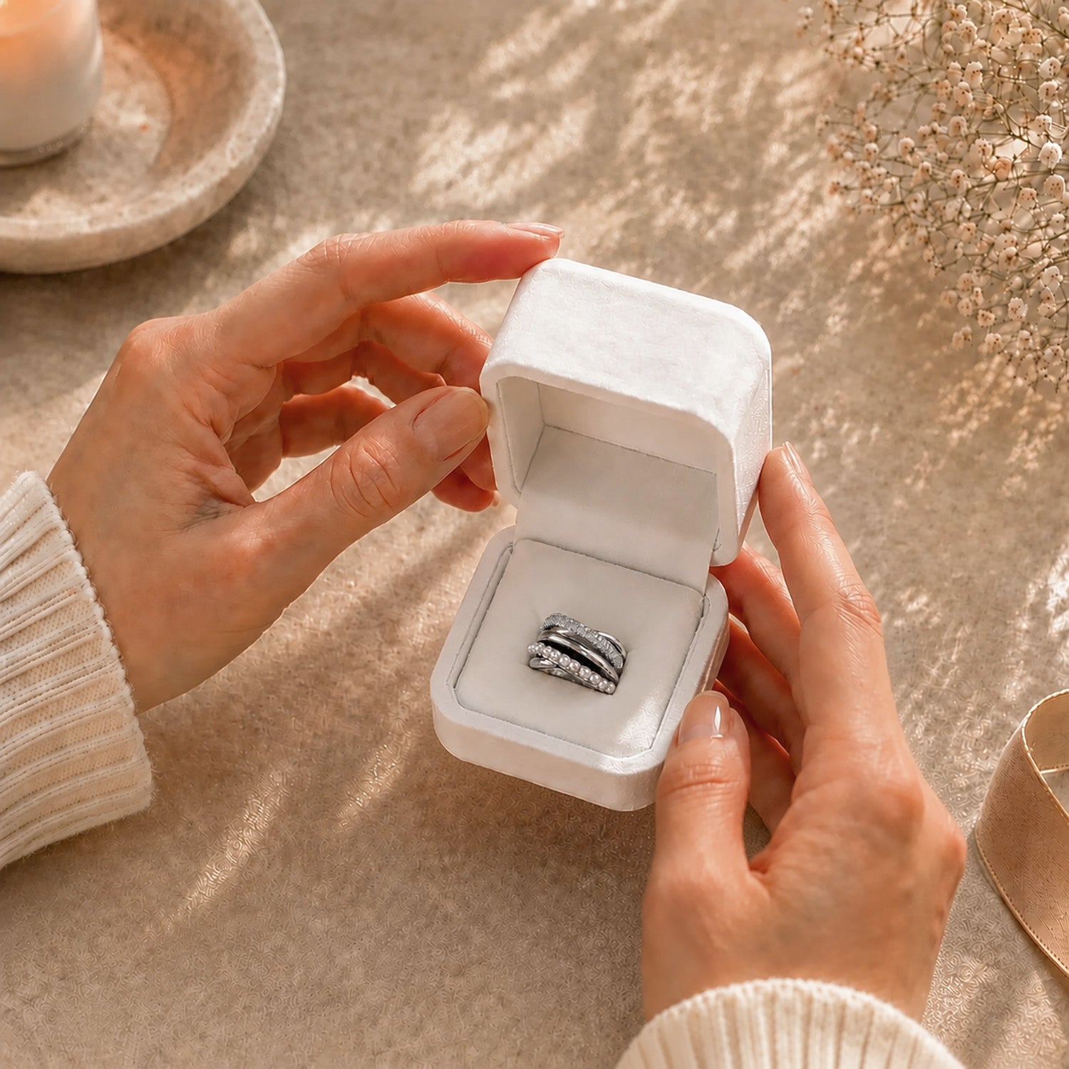 Hands gently opening a premium white Moonlook jewelry box revealing a stunning multi-layer wrapped pearl and zircon ring.