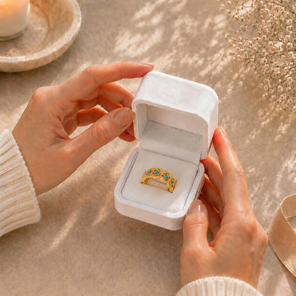 Hands gently opening a premium white Moonlook jewelry box revealing an elegant 18K gold-tone turquoise and zircon ring.