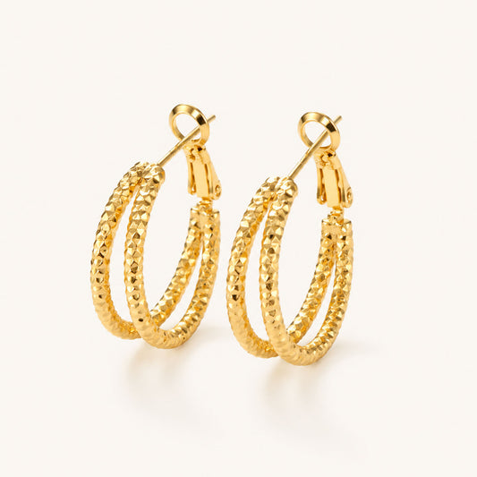 Minimalist textured double hoop earrings in a radiant gold-tone on a white background.