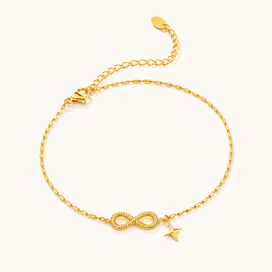 Minimalist gold-tone titanium steel anklet featuring an infinity symbol and a star charm on a white background.