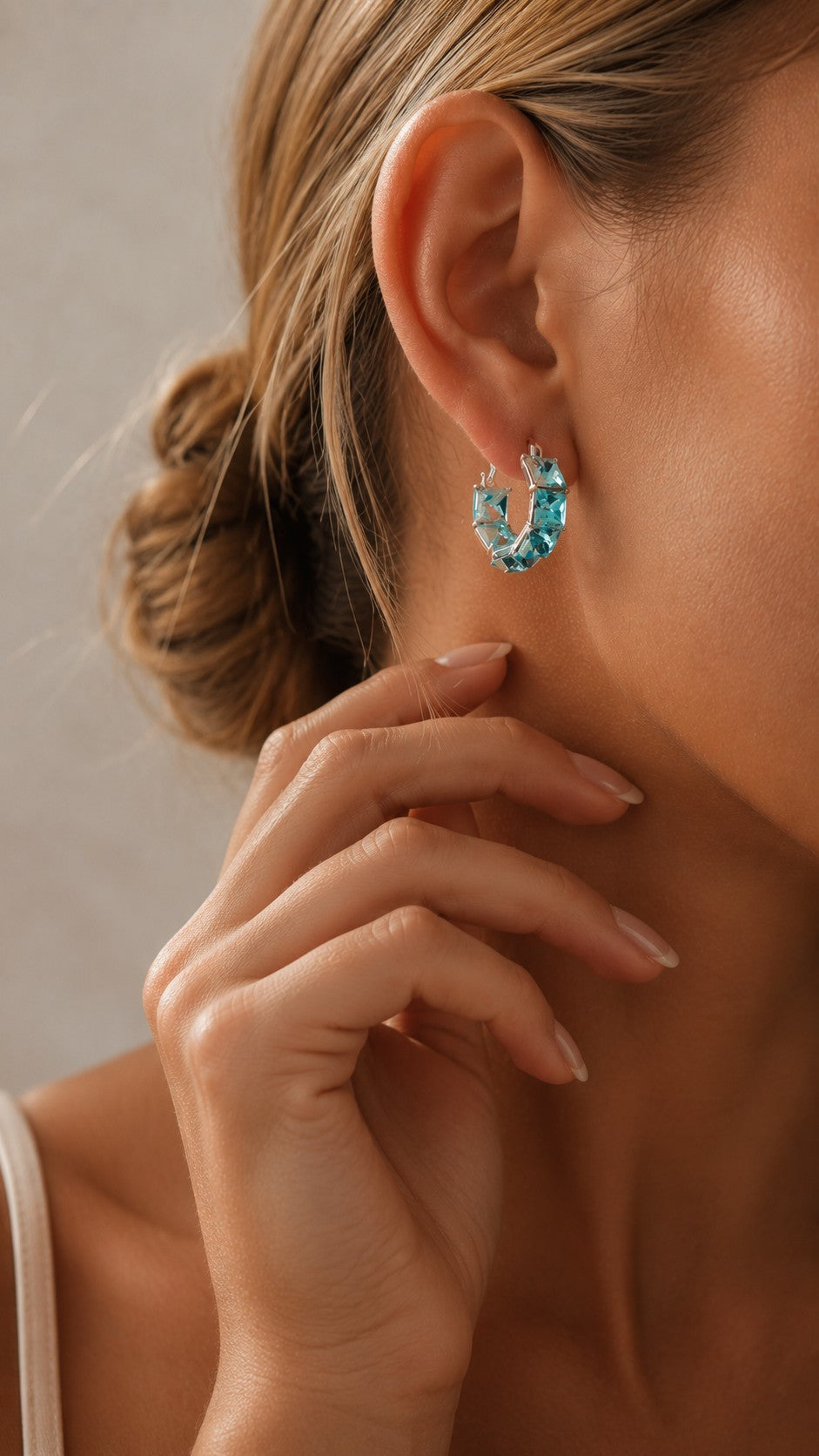 Model holding ear displaying 2cm platinum-plated ice blue square CZ hoop earring