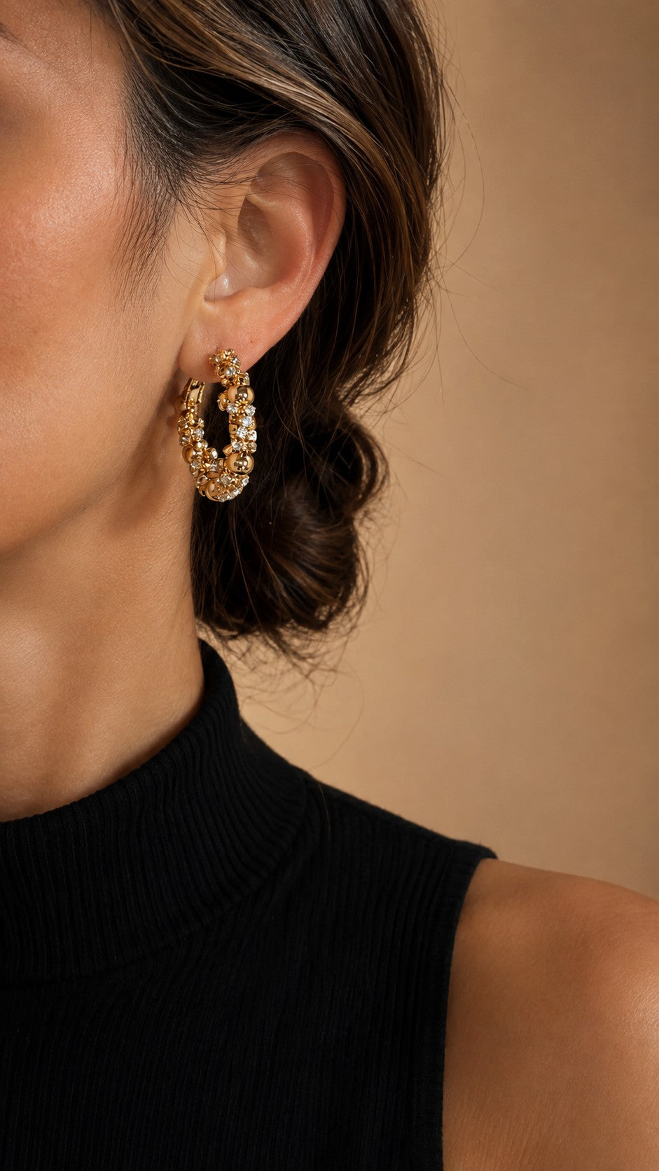 Side profile view of model with hair in a bun wearing 2.8cm chunky gold bead and cz cluster hoop earrings with black turtleneck