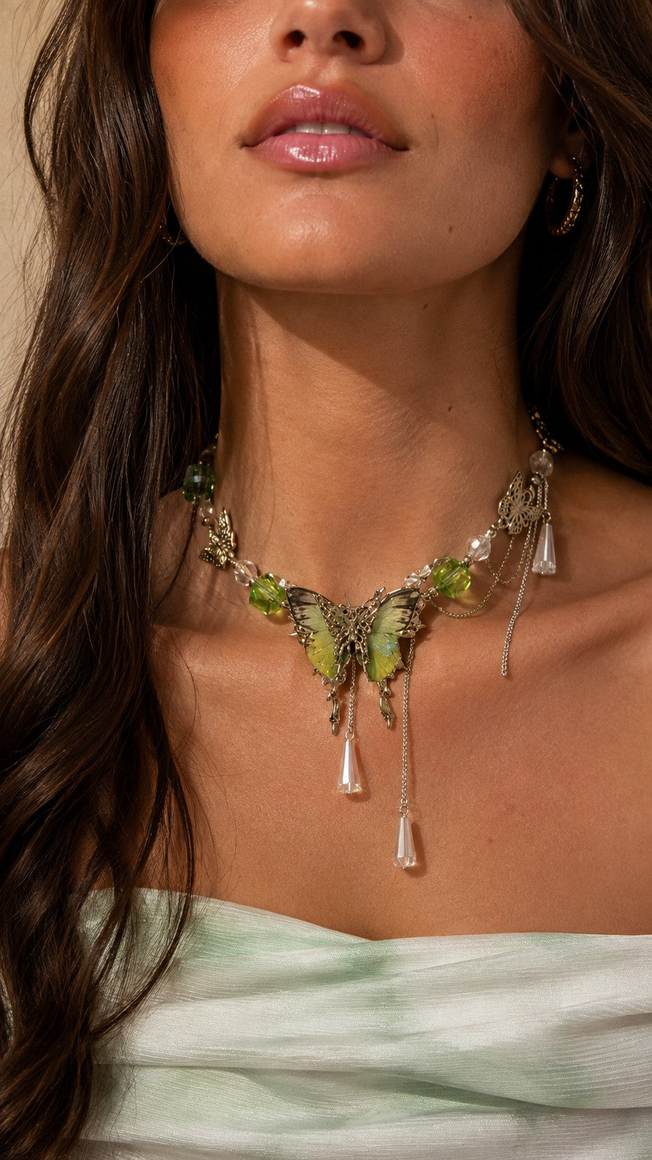 Close up of model wearing icy green crystal butterfly choker with cascading teardrop chains