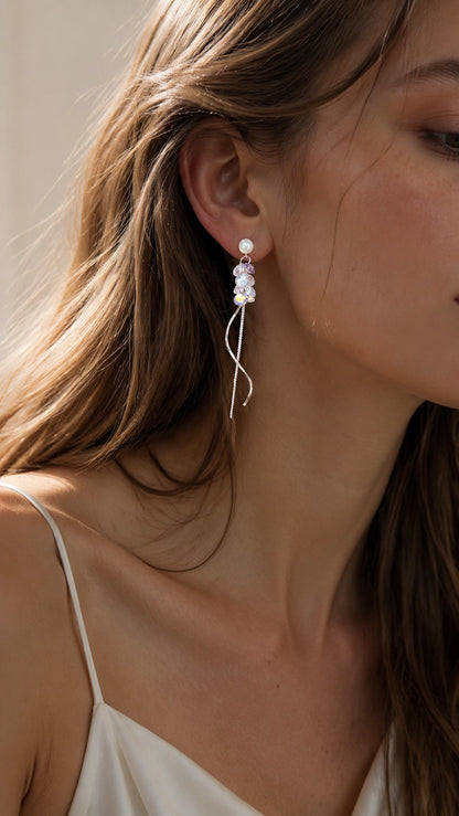 Close-up of brunette model in silk dress wearing pearl and lavender crystal wave tassel dangle earrings