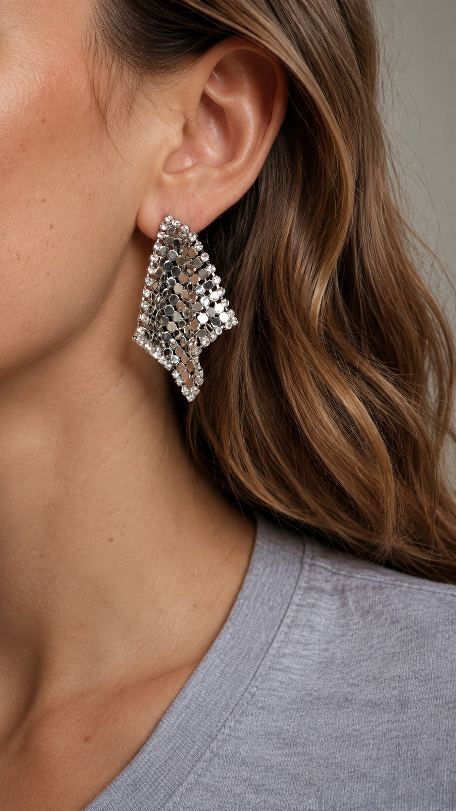 Close up of model wearing 4.3cm silver liquid metal mesh scarf rhombus stud earrings with grey top