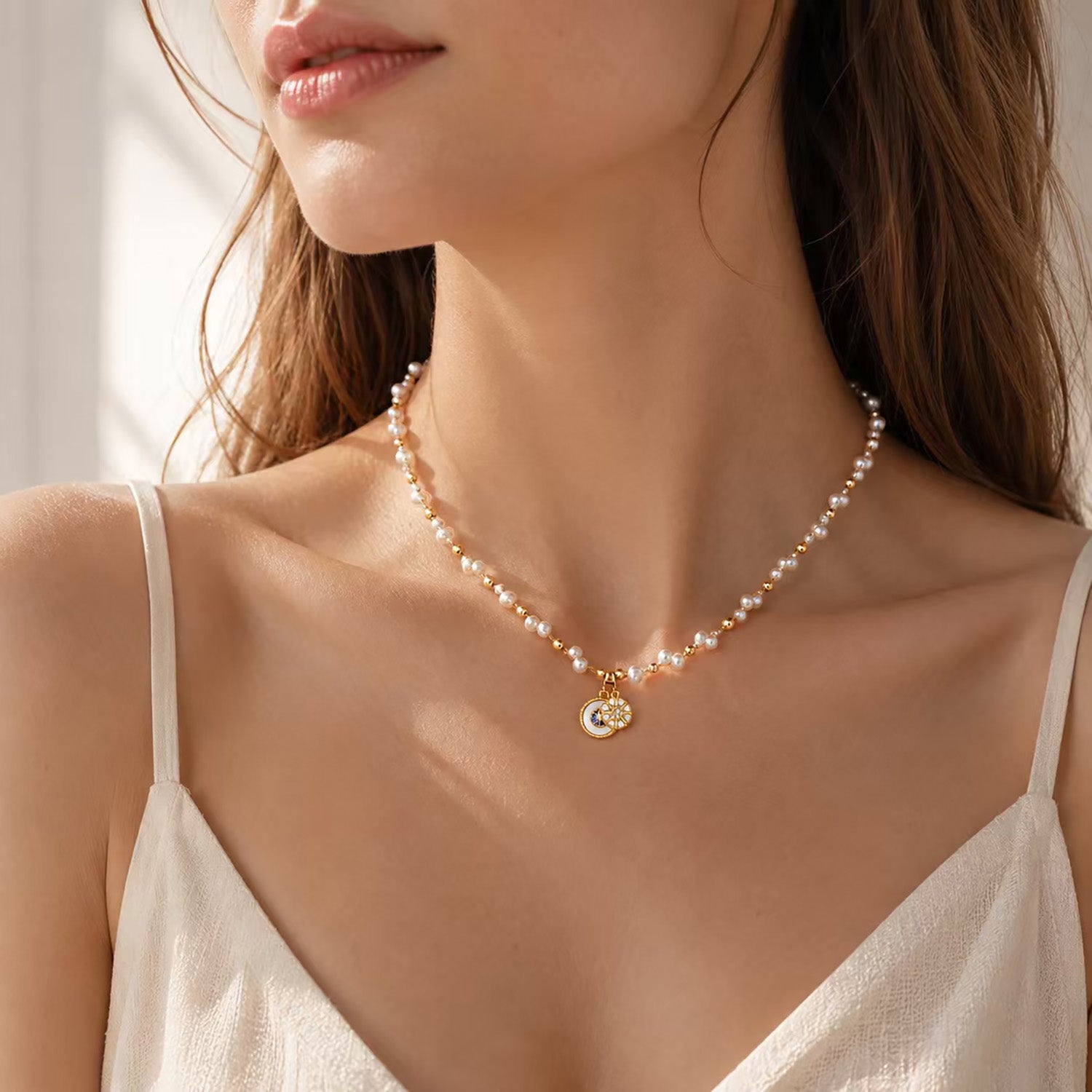 Close up of a woman wearing a delicate gold-tone and pearl vintage pendant necklace.