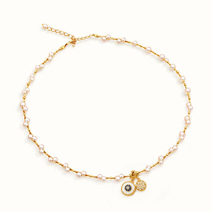 Minimalist gold-tone pearl necklace with double vintage medallions on a white background.