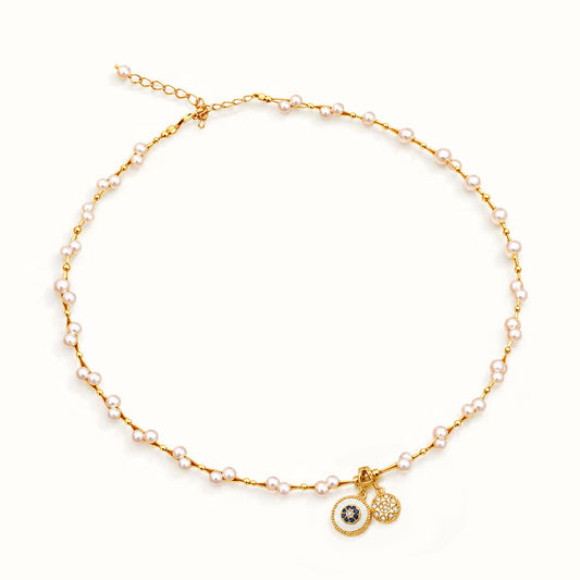 Minimalist gold-tone pearl necklace with double vintage medallions on a white background.