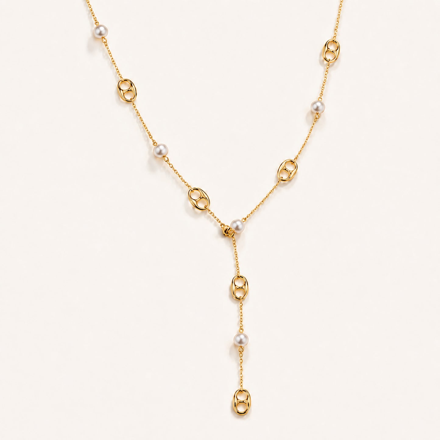 Elegant gold-tone lariat necklace featuring mother-of-pearl and anchor links on a white background.
